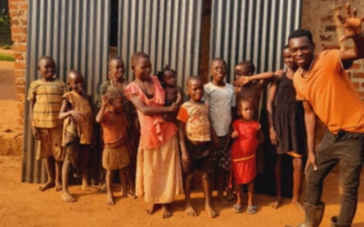 Grupa dzieci pozująca do zdjęcia przed metalową ścianą.