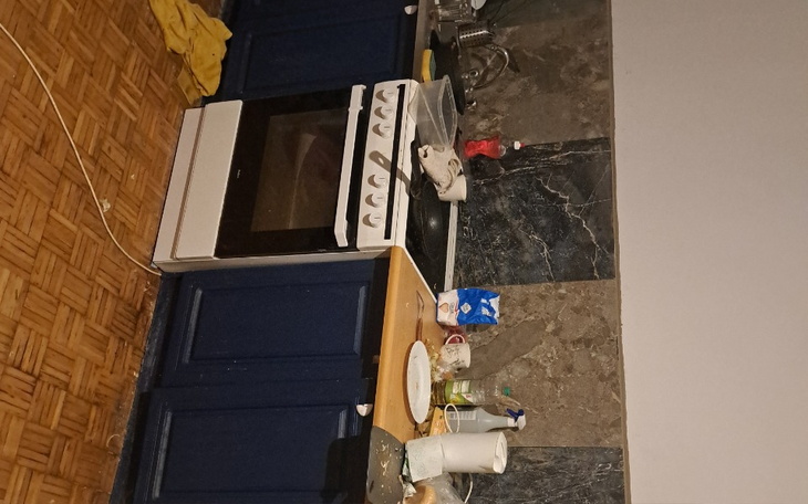 Zabłocona kuchnia z brudnymi naczyniami i sprzętem.