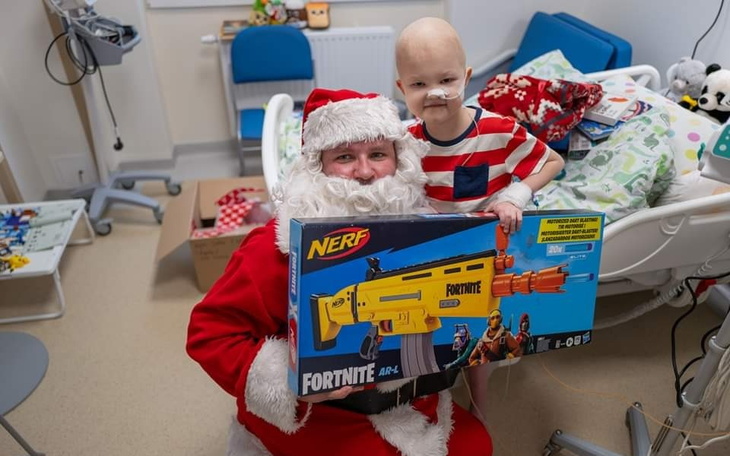 Dziecko w koszulce w paski trzymające zabawkę od Świętego Mikołaja.