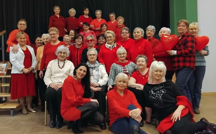 Grupa starszych kobiet w czerwonych ubraniach, pozująca do zdjęcia.