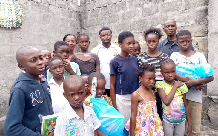 Grupa dzieci z darami w ubogiej okolicy.