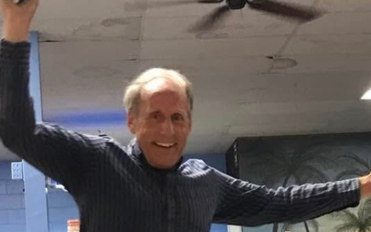 Mężczyzna tańczący w sali, z uśmiechem na twarzy.