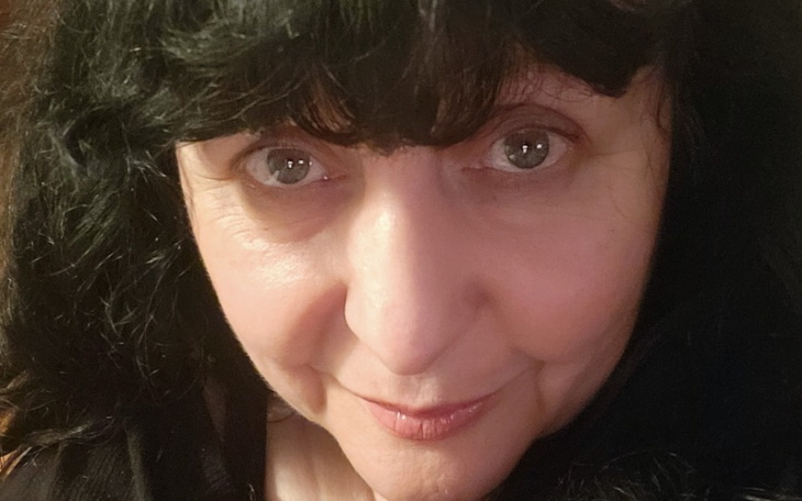 Portret kobiety z ciemnymi włosami i wyrazistymi oczami.