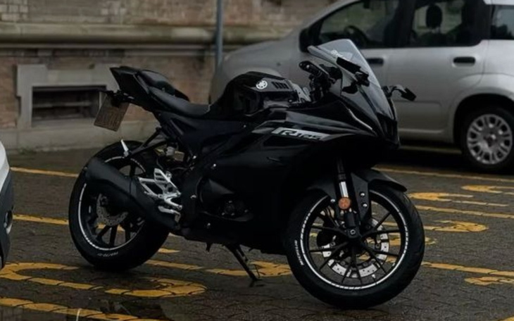 Czarny motocykl sportowy zaparkowany na ulicy.