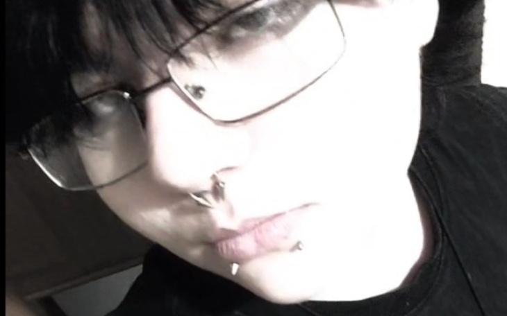 Osoba z okularami i kolczykami w ustach.