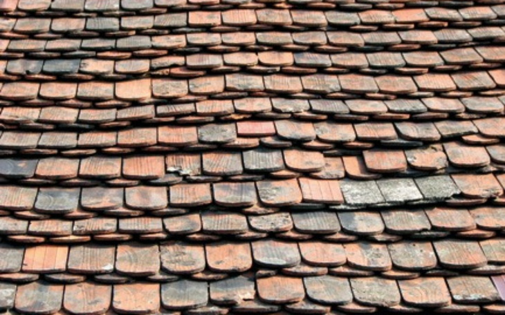 Widok na stary dach pokryty ceramicznymi dachówkami.
