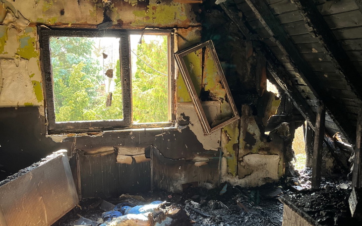 Zniszczony pokój z oknem i spalonymi ścianami.