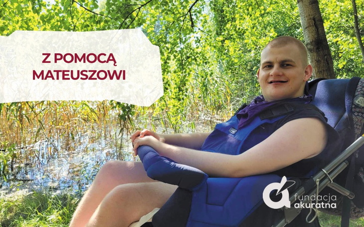 Mężczyzna w wózku inwalidzkim, uśmiechający się w otoczeniu natury.