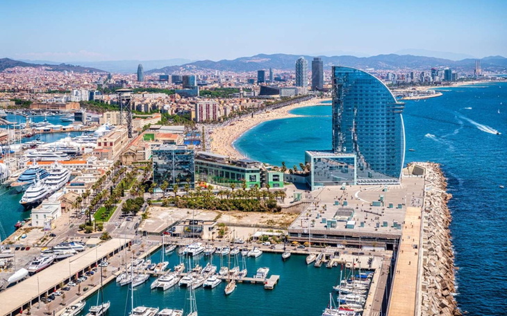 Widok na plażę i nowoczesne budynki nad morzem.