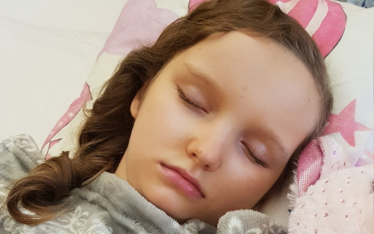 Dziewczynka śpiąca z pluszowym misiem.