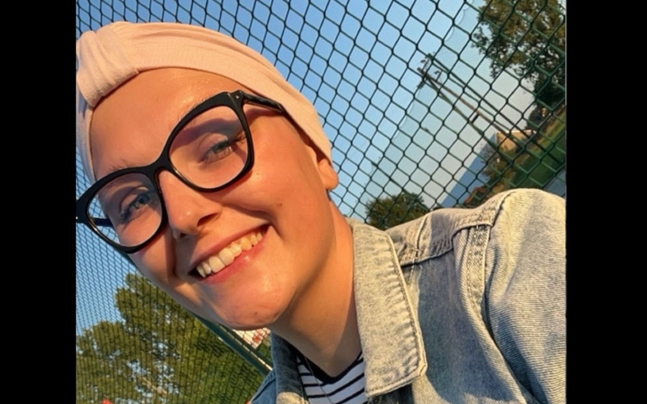 Uśmiechnięta dziewczyna w okularach, ciesząca się słonecznym dniem na boisku.