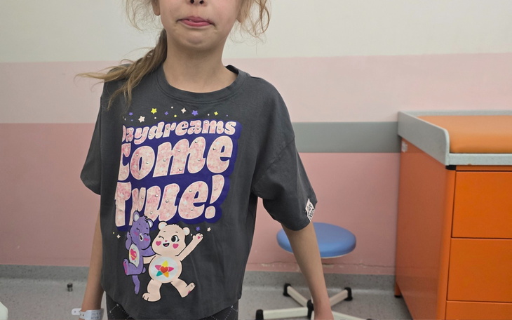 Dziewczynka w koszulce z postaciami z kreskówki.