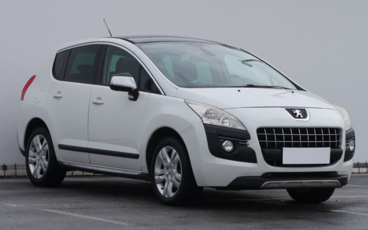 Biały samochód marki Peugeot zaparkowany.