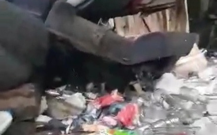 Zniszczony samochód otoczony śmieciami.