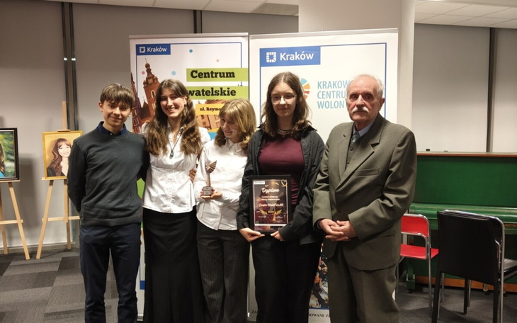 Grupa ludzi na wydarzeniu, trzymają nagrody i dyplomy.