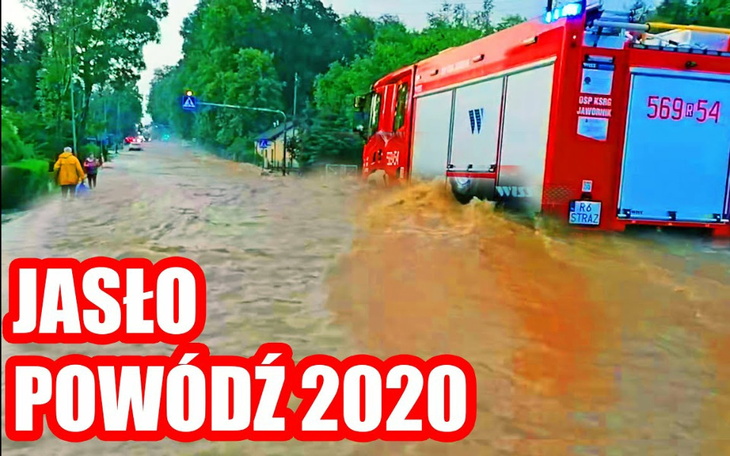 Scena powodzi w Jaśle, z wozem strażackim w wodzie.