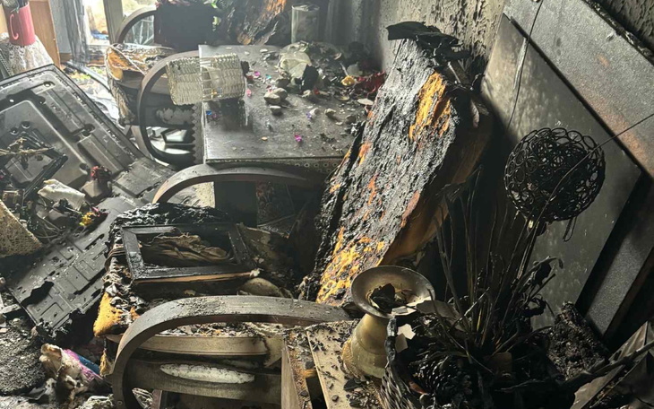 Zniszczone wnętrze po pożarze, z popiołem i zniszczeniami.