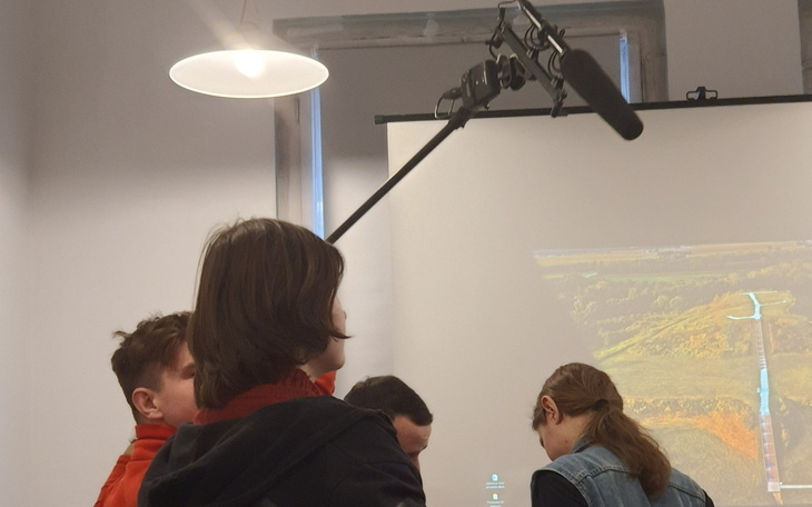 Osoba z mikrofonem w studiu podczas prezentacji.