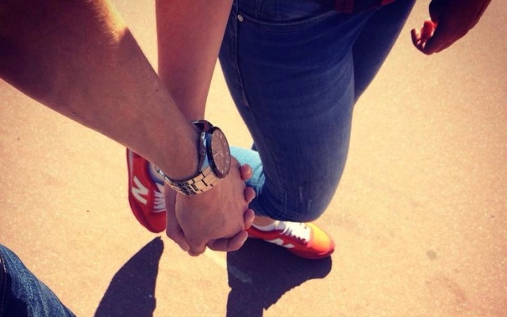 Dwie osoby trzymające się za ręce, widok z góry.