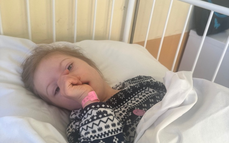 Chora dziewczynka leżąca w szpitalnym łóżku.