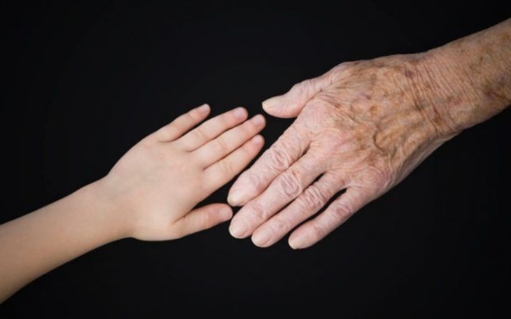 Dwie dłonie, młodsza i starsza, symbolizujące pokolenia.