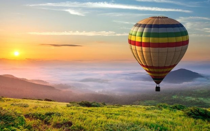 Balon na gorące powietrze unoszący się nad malowniczym krajobrazem.