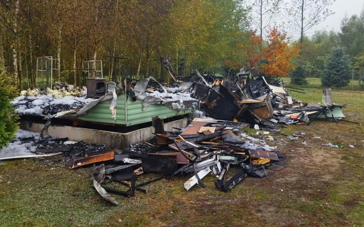 Zniszczony przez pożar budynek w otoczeniu jesiennego lasu