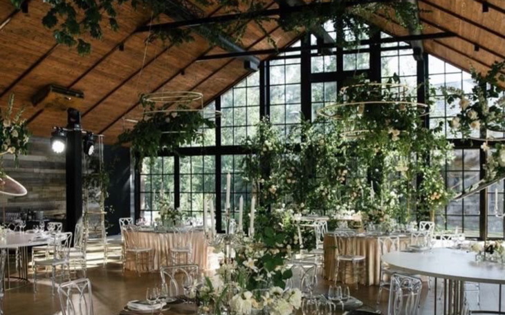Elegancka sala weselna z dekoracjami roślinnymi.