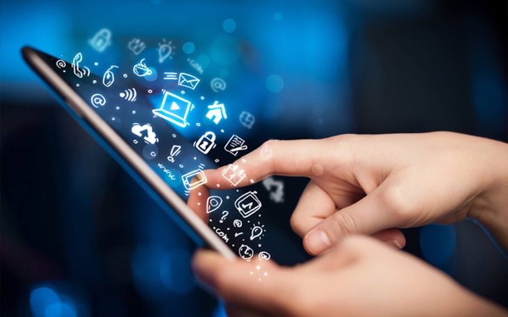 Ręka dotykająca ekranu smartfona z ikonami aplikacji.