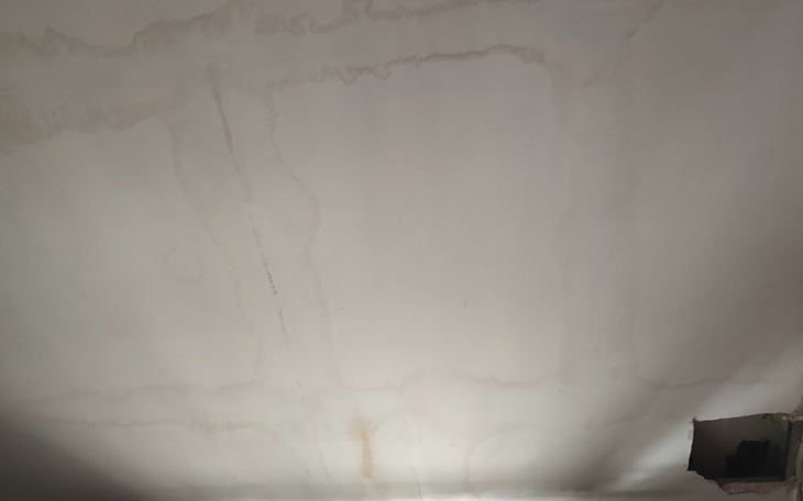 Zniszczony sufit w budynku, z widocznymi plamami.
