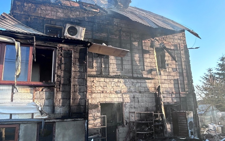 Zniszczony budynek po pożarze, z uszkodzoną elewacją.