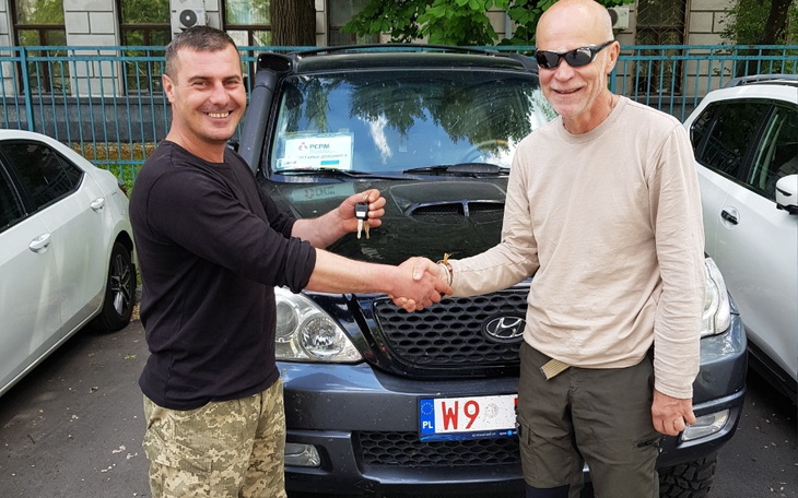 Dwóch mężczyzn wymieniających kluczyki do samochodu.