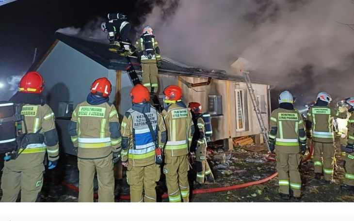 Strażacy gaszący pożar w zniszczonym budynku.