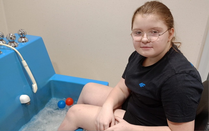 Dziewczynka w wannie z bąbelkami, relaksuje się.