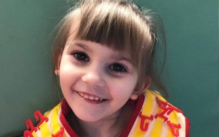 Uśmiechnięta dziewczynka w kolorowej kamizelce.