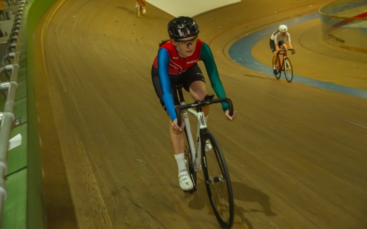 Kobieta na torze kolarskim, w akcji podczas wyścigu.