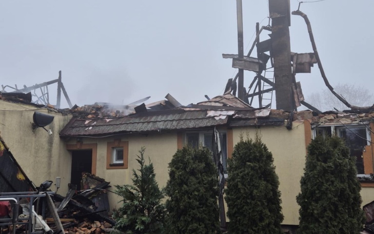 Zniszczony dom po pożarze, z widocznymi uszkodzeniami.