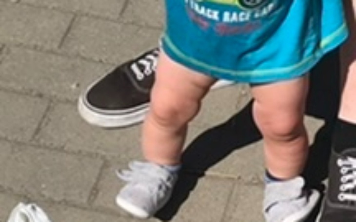 Dziecięce nóżki w sportowych butach na chodniku.