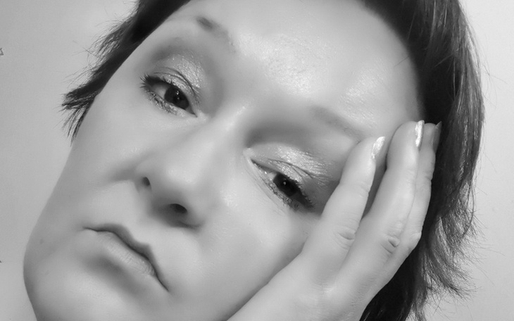 Kobieta w czarno-białym portrecie, z wyrazem zamyślenia.