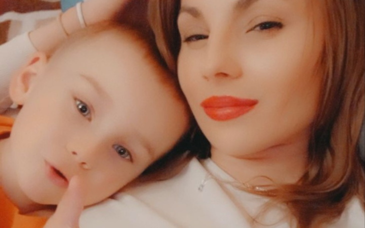 Kobieta z dzieckiem, oboje uśmiechnięci, spędzają czas razem.