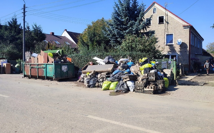 Zamieć śmieci przed budynkiem, z dużą ilością odpadów.