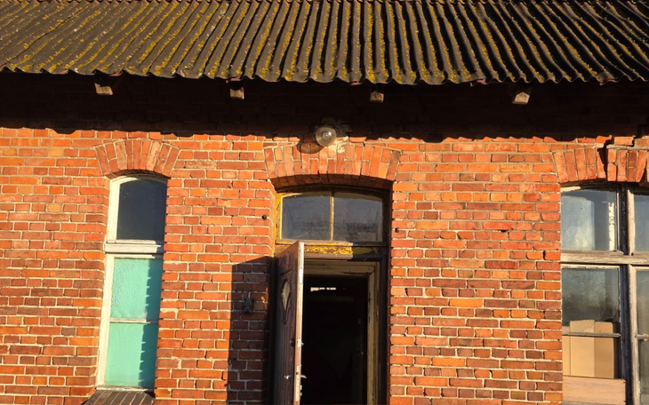 Czerwony budynek z cegły z otwartymi drzwiami.