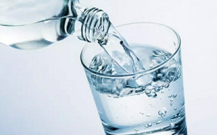 Woda nalewana do szklanki, tworząca bąbelki.