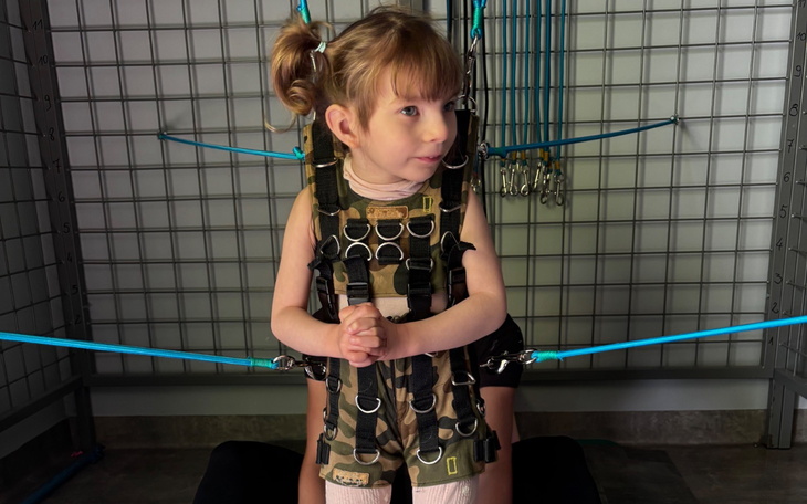 Dziewczynka w uprzęży, przygotowująca się do ćwiczeń.