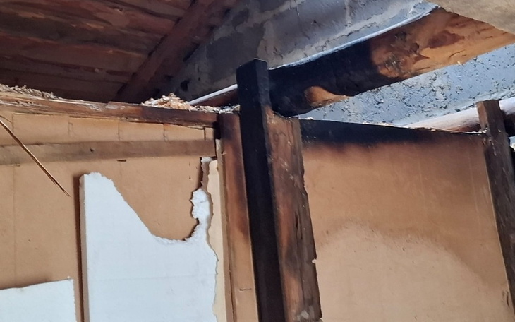 Zniszczona ściana z oznakami pożaru.