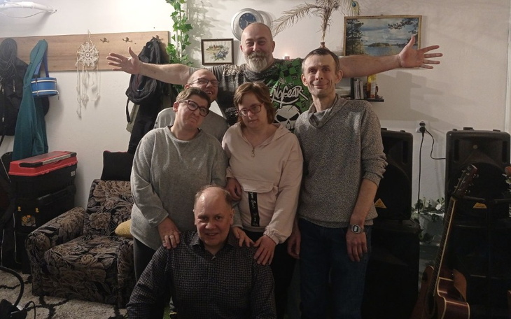 Grupa przyjaciół pozująca razem w przytulnym wnętrzu.