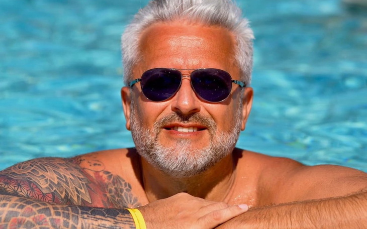Mężczyzna w okularach przeciwsłonecznych relaksujący się w basenie.