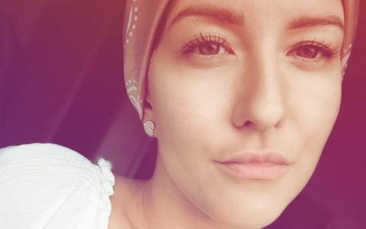 Kobieta w turbanie, z delikatnym uśmiechem.