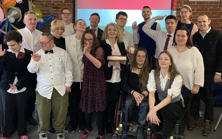 Grupa ludzi na wydarzeniu, świętująca okrągłą rocznicę.