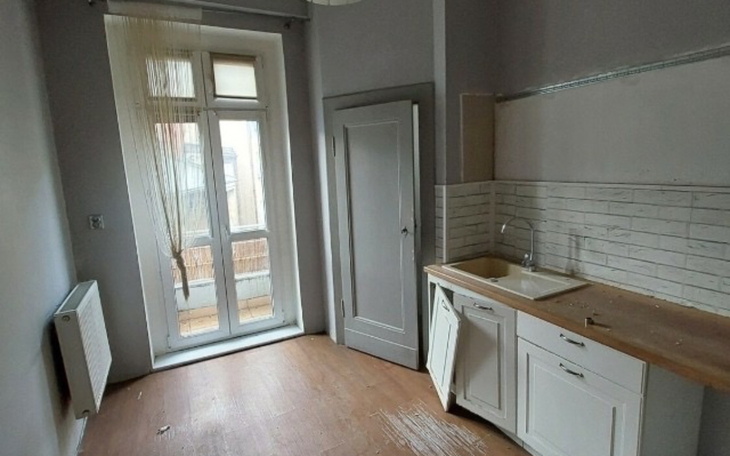 Pusty, jasny pokój z otwartymi drzwiami na balkon.